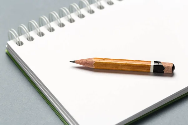 Lápis desgastado curto com bloco de notas na mesa cinza — Fotografia de Stock