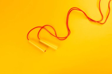 Jumping rope on yellow background. creative photo.
