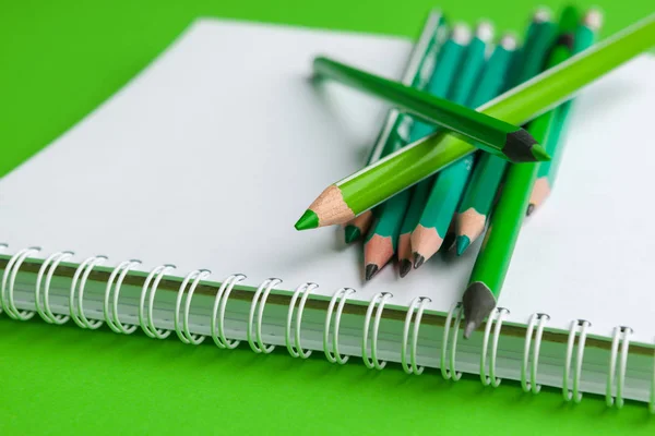 Egy halom ceruza élénk zöld háttérrel — Stock Fotó