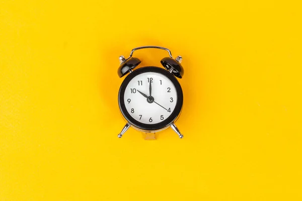 Reloj despertador sobre fondo amarillo brillante de cerca — Foto de Stock