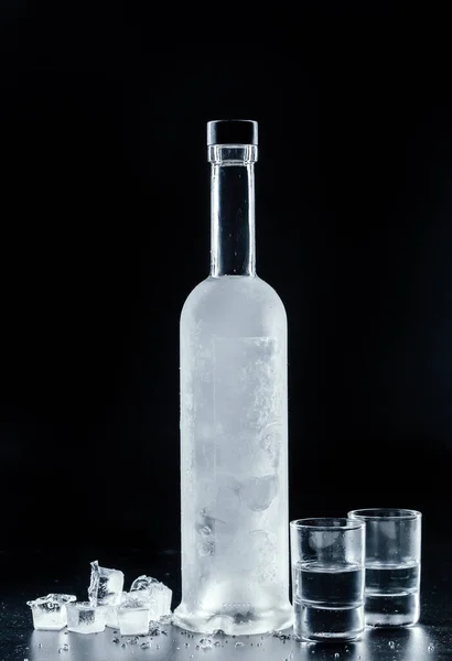 Бутылка холодной водки на тёмном фоне — стоковое фото