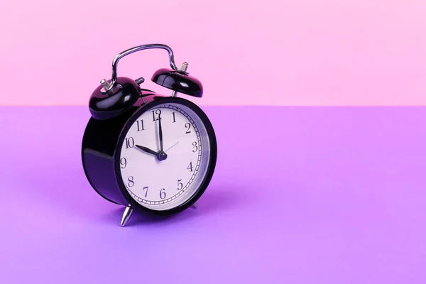 Vintage relógio de alarme preto no fundo lilás — Fotografia de Stock