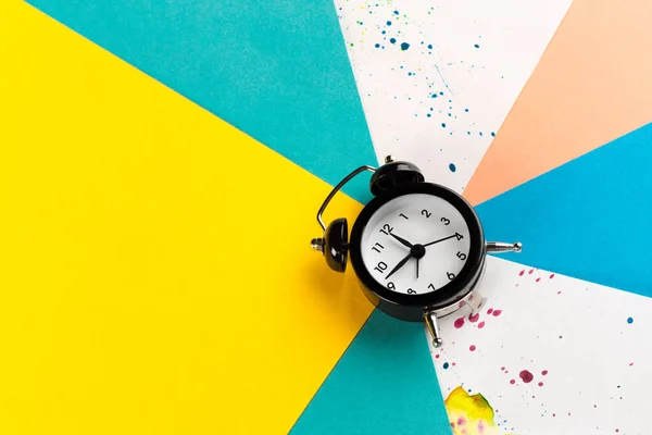 Relógio de alarme vintage em um fundo colorido criativo com borrifos de tinta — Fotografia de Stock