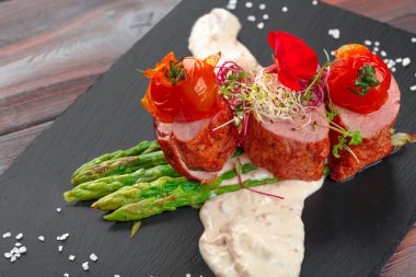 Siyah bulaşık takımında kuşkonmaz ve ahşap masa.