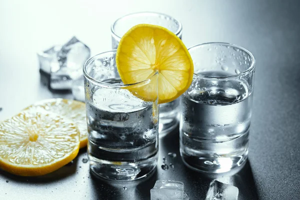 Kall vodka i shotglasögon på en svart bakgrund. — Stockfoto