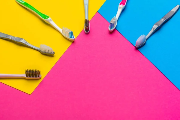 Flat lay composition with manual toothbrushes on color background, close up. creative photo. — Stock Photo, Image