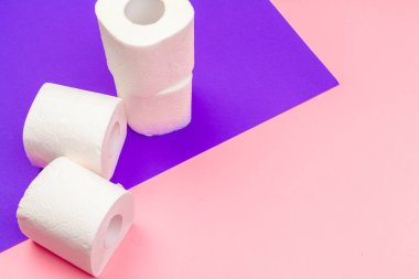 Beyaz tuvalet kağıdı parlak renk bloğu arka planında yuvarlanır