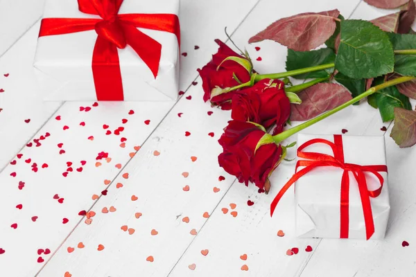 Saint-Valentin. Roses rouges et coffret cadeau sur table en bois — Photo