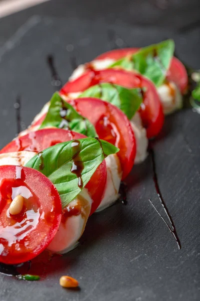 Ensalada caprese italiana fresca con mozzarella y tomates en plato oscuro —  Fotos de Stock