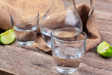 Temiz suda elma dilimleri ve ahşap bir masada taze bir elma ile beslenme içeceği, yakın çekim. yaratıcı fotoğraf.