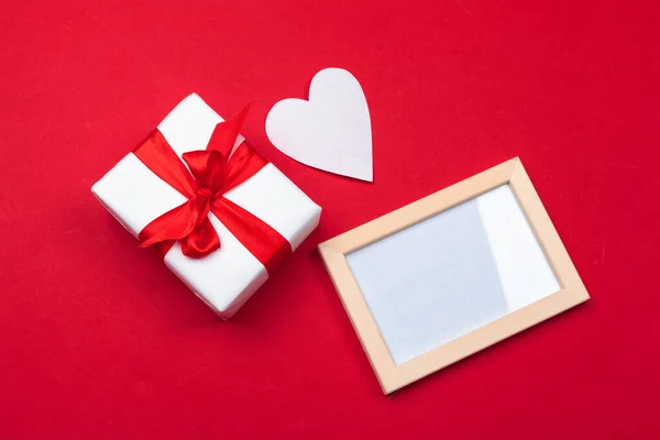 Tarjeta de felicitación de San Valentín. caja de regalo en la mesa roja. Vista superior con espacio de copia — Foto de Stock