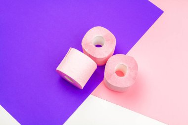 Parlak renk bloğu arka planında Pastel pembe tuvalet kağıdı