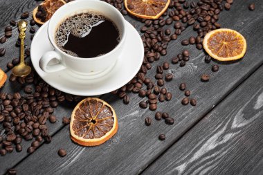 Tahta arka planda bir fincan kahve ve fasulye.