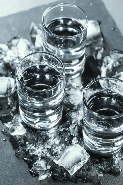 Cold vodka in shot glasses on a black background. — Stock Photo, Image