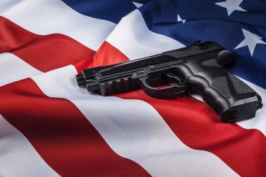 Amerikan bayrağında duran tabanca. Silah sorunu kavramı