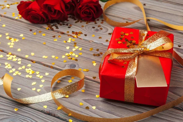 Sevgililer Günü. Kırmızı güller ve hediye kutusu ahşap masada — Stok fotoğraf