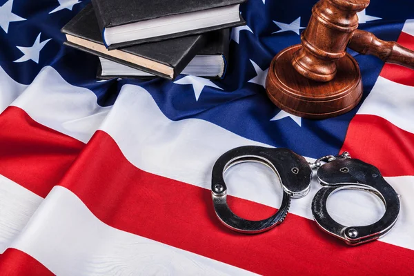 Gavel, Handschellen und amerikanische Flagge auf Holzgrund. — Stockfoto