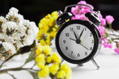 Bahar Saati Değişimi Çalar saat ve çiçek dalları ile arka plan