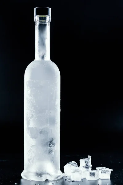 Butelka zimnej wódki na ciemnym tle — Zdjęcie stockowe