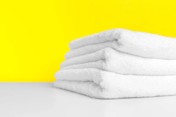 Saubere weiche Handtücher auf farbigem Hintergrund. kreatives Foto. — Stockfoto