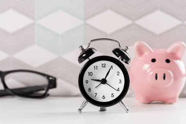 Zaman kazanmak için çalar saat ve domuz kumbarası kavramı — Stok fotoğraf