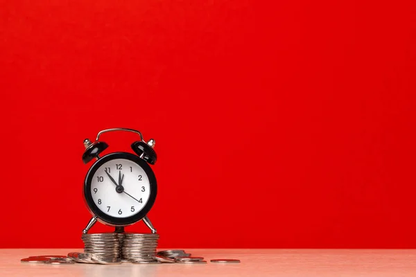 El tiempo es dinero, reloj de mesa con monedas. foto creativa . — Foto de Stock