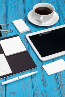 Marka kırtasiye modeli mavi masada. Kağıt, kartvizit, ped, kalem ve kahvenin üst görüntüsü.