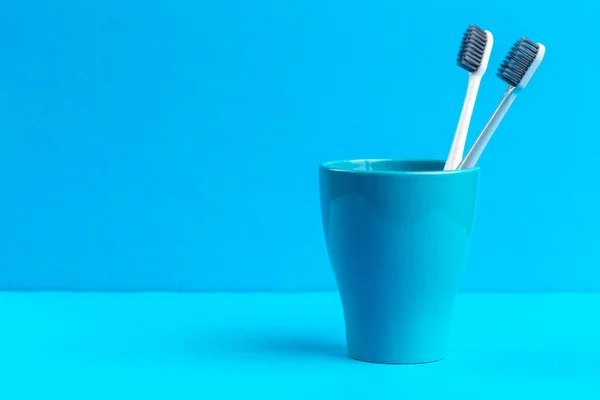 Toothbrushes in glass on the table. creative photo. — Stock Photo, Image