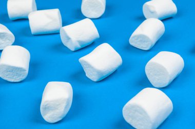 Marshmallows on blue background. close up. creative photo.