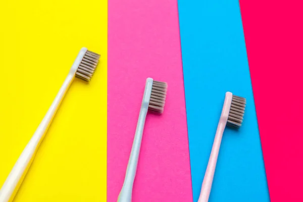 Composición plana con cepillos de dientes manuales sobre fondo de color, de cerca. foto creativa . — Foto de Stock