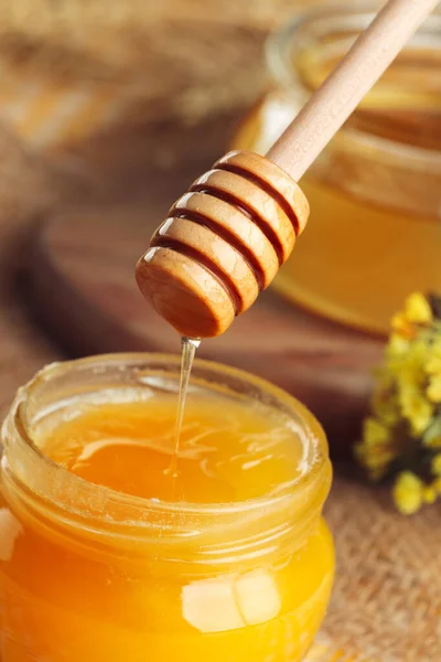 Honey background. Sweet honey in glass jar on wooden background.