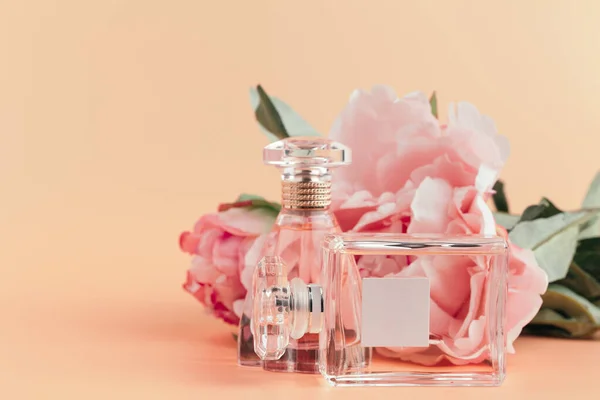 Eine Flasche Parfüm mit Blumen auf hellem Tuch — Stockfoto