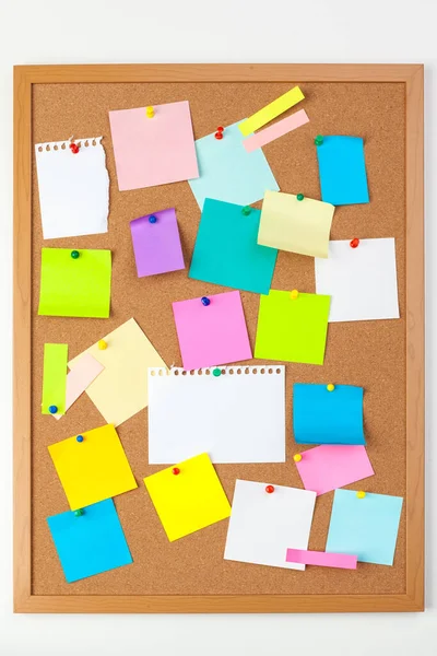 Cork board with several colorful blank notes with pins — Stock Photo, Image