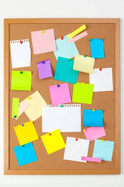 Cork board with several colorful blank notes with pins Royalty Free Stock Images