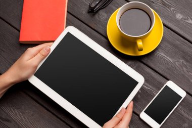 Boş tablet aygıtı, ahşap çalışma masasının üzerinde, kahve masası manzaralı.
