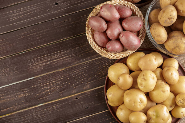Fresh potatoes on the wood background. creative photo.