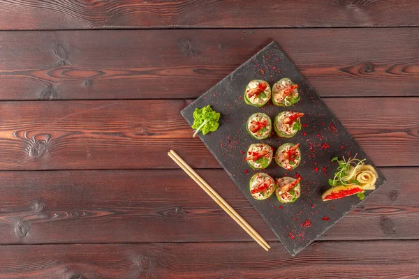 Frisches Sushi auf rustikalem Holztisch. kreatives Foto. — Stockfoto