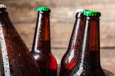 Tahta arka plandaki kovada soğuk bira şişeleri var.