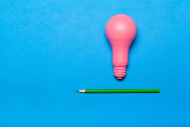 Creative idea concept. Pink lightbulb and pencil top view