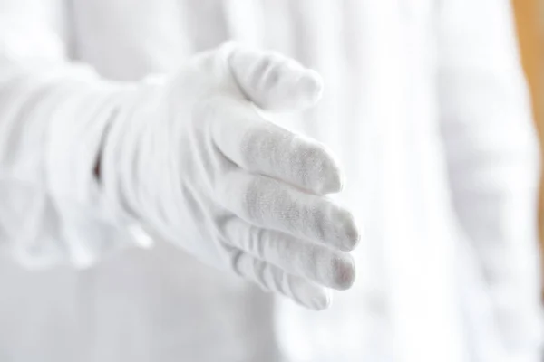 A hand in white glove is ready to shake — Stock fotografie