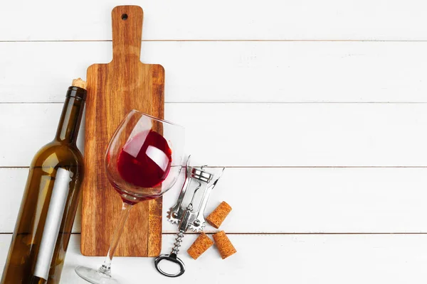 Bottle of wine and cork and corkscrew on wooden table — Stock Photo, Image