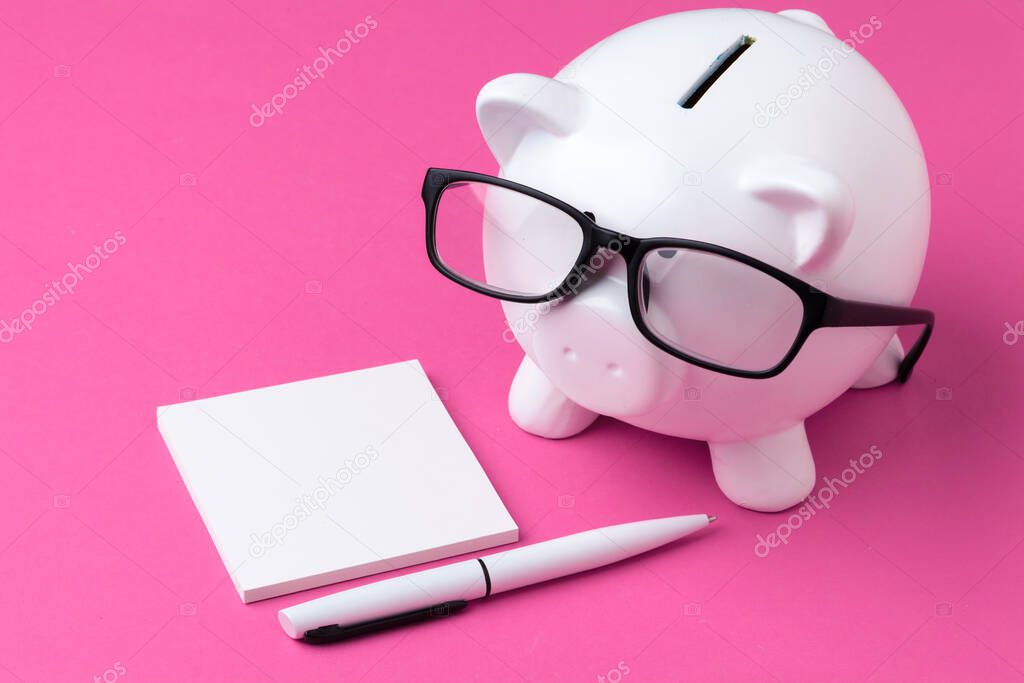 Piggy bank and notebook with a pen