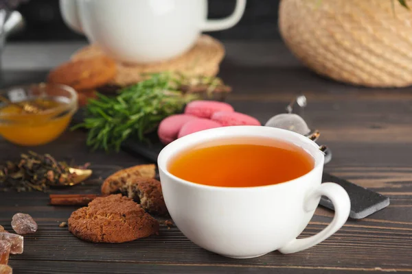 Théière en verre avec tasse de thé noir sur table en bois — Photo