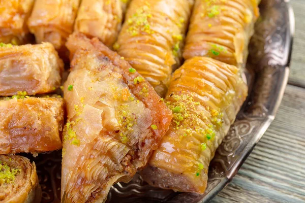 Bandeja oriental de metal y baklava dulces turcos sobre fondo de madera — Foto de Stock