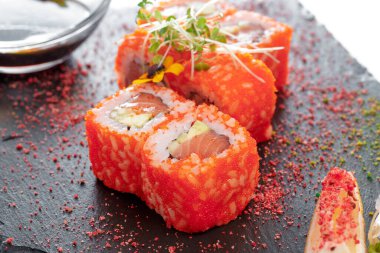 Suşi ile siyah dikdörtgen tabak, beyaz üzerine izole.