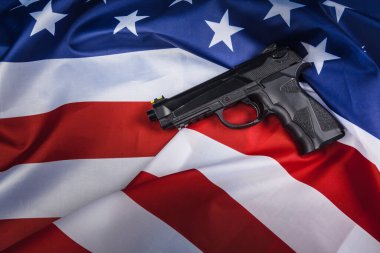 Amerikan bayrağında duran tabanca. Silah sorunu kavramı