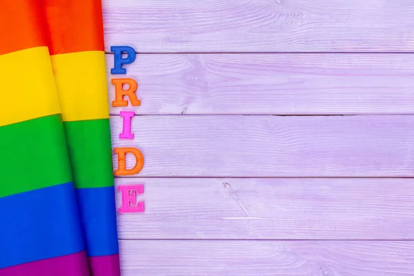 Bandera de orgullo gay en mesa de madera. foto creativa . — Foto de Stock