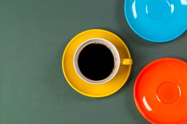 Masanın üstünde parlak renkli kahve fincanı.