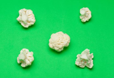 Parlak yeşil arka planda karnabahar parçaları