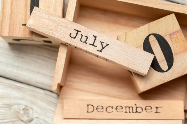 Bovenaanzicht van delen van houten kalender op donker houten tafelblad — Stockfoto